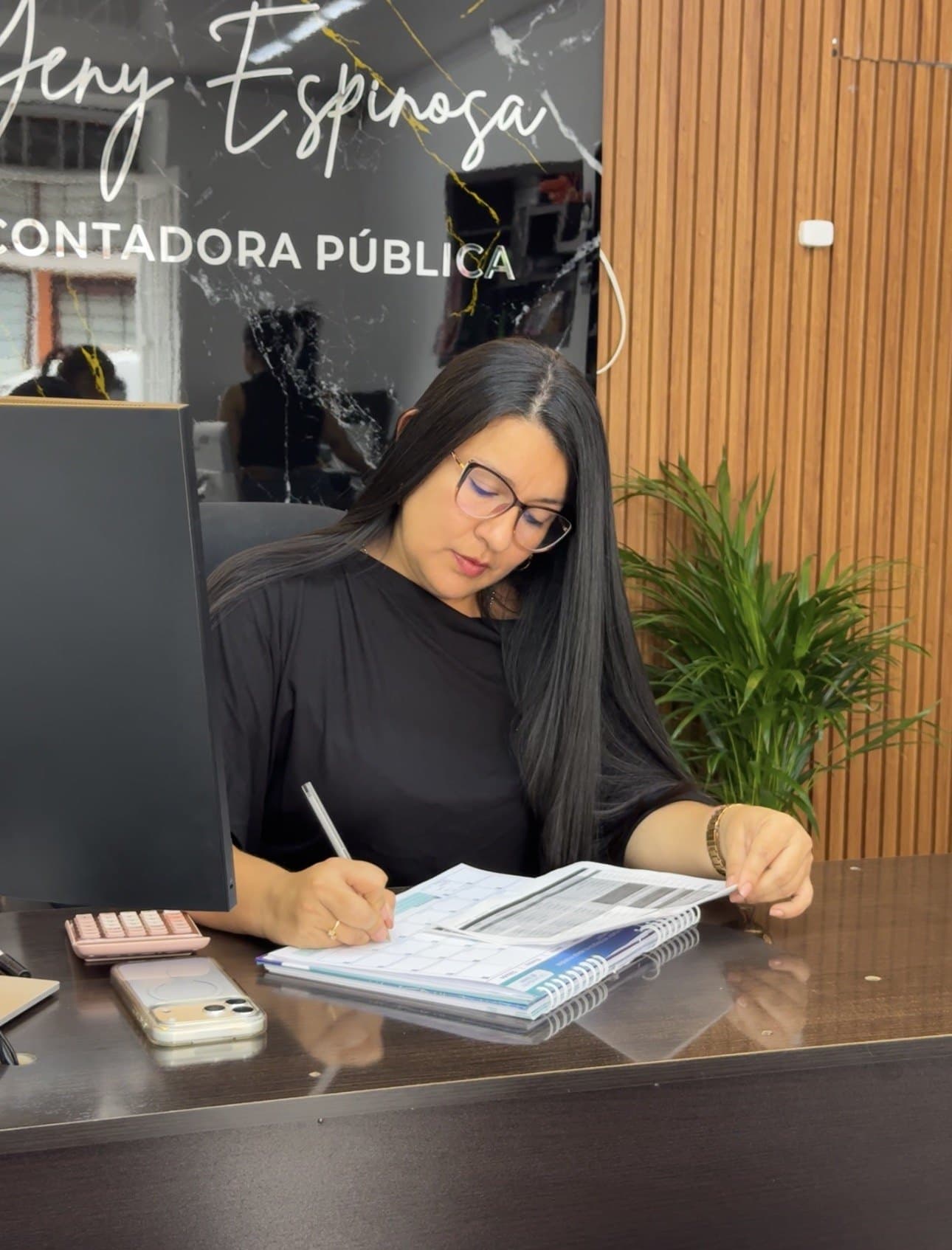 Yeny Espinosa revisando documentos en su escritorio